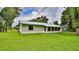 This is a nice backyard view of the house with a metal roof and a green lawn at 1017 Chippewa Trl, Daytona Beach, FL 32117