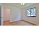 Bright bedroom with wood-look flooring, ceiling fan, and a large window providing natural light at 1017 Chippewa Trl, Daytona Beach, FL 32117
