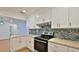 Modern kitchen featuring white cabinets, stainless steel appliances, and stylish backsplash at 1017 Chippewa Trl, Daytona Beach, FL 32117