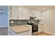 Bright kitchen with white cabinets, stainless steel range, and colorful backsplash at 1017 Chippewa Trl, Daytona Beach, FL 32117