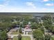 Aerial view of home in lush neighborhood with beautiful water views in the distance and a newly installed metal roof at 1085 Indigo Rd, Ormond Beach, FL 32174