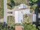 Aerial view of a property with boat dock, sheds, large driveway, and mature trees at 1085 Indigo Rd, Ormond Beach, FL 32174