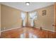 Empty bedroom featuring hardwood floors, two windows with white curtains, and neutral-colored walls at 1085 Indigo Rd, Ormond Beach, FL 32174