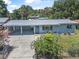 Aerial view of a blue single-story home with a metal roof, a covered driveway, and a fenced yard at 1085 Indigo Rd, Ormond Beach, FL 32174