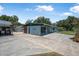 Exterior view featuring a covered parking area, a separate building, and a well-manicured lawn at 1085 Indigo Rd, Ormond Beach, FL 32174