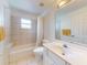 Bright bathroom featuring a shower-tub combination with tiled walls and a white vanity at 1104 W Seagate Dr, Deltona, FL 32725
