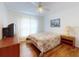 Cozy bedroom with wood floors, a ceiling fan, and an inviting floral-patterned bedspread at 1104 W Seagate Dr, Deltona, FL 32725