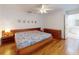 Comfortable bedroom featuring a ceiling fan, wood floors, and view of the bathroom at 1104 W Seagate Dr, Deltona, FL 32725