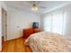 Inviting bedroom with wood floors, a ceiling fan, and a colorful floral bed set at 1104 W Seagate Dr, Deltona, FL 32725