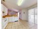 Spacious kitchen area with neutral tile flooring, white appliances, and access to lanai at 1104 W Seagate Dr, Deltona, FL 32725
