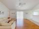 Bright living room with wood floors, comfortable seating, and sliding glass door to lanai at 1104 W Seagate Dr, Deltona, FL 32725