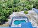 Overhead view of the screened-in pool, surrounded by lush greenery and sandy backyard at 1104 W Seagate Dr, Deltona, FL 32725