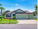 Inviting one-story home features a well-manicured lawn, three-car garage, and beautiful desert-toned color palette at 112 Tuscany Bend St, Daytona Beach, FL 32117