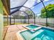 Enclosed pool featuring clear blue water, a jacuzzi, and a brick deck, enhancing outdoor enjoyment at 112 Tuscany Bend St, Daytona Beach, FL 32117
