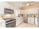 Modern kitchen featuring white cabinets, stainless steel appliances, and a stylish marble backsplash at 118 N Sunland Dr, Sanford, FL 32773