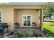 Inviting back porch with comfortable seating, a grill, and potted plants, creating a relaxing outdoor space at 118 Tuscany Villas Dr, Edgewater, FL 32141
