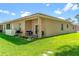 Serene backyard featuring a covered patio with seating, a grill, and lush green lawn perfect for outdoor enjoyment at 118 Tuscany Villas Dr, Edgewater, FL 32141
