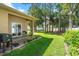 Charming backyard with covered patio, a grill, green lawn, and privacy fence, perfect for outdoor gatherings at 118 Tuscany Villas Dr, Edgewater, FL 32141