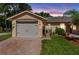 Charming single-story home showcasing a well-maintained lawn, brick driveway, and attached two-car garage at 118 Tuscany Villas Dr, Edgewater, FL 32141