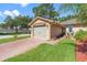 Quaint home featuring a two-car garage, brick-paved driveway, and verdant landscaping at 118 Tuscany Villas Dr, Edgewater, FL 32141