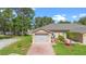 Attractive villa boasts a two-car garage, brick-paved driveway, and manicured lawn at 118 Tuscany Villas Dr, Edgewater, FL 32141