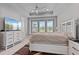 Bright bedroom featuring an expansive view of the lake, with tray ceilings and large windows at 141 Mosaic Blvd, Daytona Beach, FL 32124