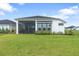Back of house showing screened-in porch and well-maintained lawn at 141 Mosaic Blvd, Daytona Beach, FL 32124