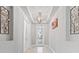 Bright foyer featuring decorative lighting, a tray ceiling, and a glass-paneled front door at 141 Mosaic Blvd, Daytona Beach, FL 32124