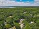 Stunning aerial view of a property surrounded by lush trees, showcasing privacy and access to nature at 1516 Arrowhead Trl, Enterprise, FL 32725