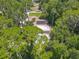 Aerial view of the home features a pool and lush green surrounding trees, offering privacy and tranquility at 1516 Arrowhead Trl, Enterprise, FL 32725