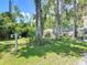 The lush, shady backyard features mature trees and green grass, ideal for outdoor activities and relaxation at 1516 Arrowhead Trl, Enterprise, FL 32725
