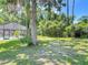 Lush backyard with mature trees and a screened-in pool enclosure providing shade and privacy at 1516 Arrowhead Trl, Enterprise, FL 32725