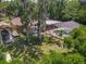Aerial view of a charming home with a screened pool, beautiful landscaping and a fire pit in the backyard at 1516 Arrowhead Trl, Enterprise, FL 32725