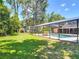 A beautifully landscaped backyard featuring a screened-in pool and lush greenery offering privacy and tranquility at 1516 Arrowhead Trl, Enterprise, FL 32725