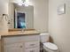 Cozy bathroom featuring a single sink vanity, large mirror, and a toilet with neutral wall color at 1516 Arrowhead Trl, Enterprise, FL 32725