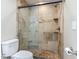 Modern bathroom offers a glass-enclosed shower with tiled walls and a built-in seat, plus a comfort-height toilet at 1516 Arrowhead Trl, Enterprise, FL 32725