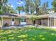 Well-maintained home featuring a spacious lawn, beautiful landscaping, and a screened-in patio at 1516 Arrowhead Trl, Enterprise, FL 32725