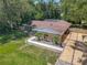An exterior elevation showcases a charming home with a well-manicured lawn, lush landscaping and a spacious driveway at 1516 Arrowhead Trl, Enterprise, FL 32725