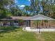 Inviting single-story home with manicured lawn, mature palms, and a charming screened front entry at 1516 Arrowhead Trl, Enterprise, FL 32725