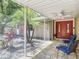 Screened in front porch with tile flooring, ceiling fan, outdoor chairs and a double door entry at 1516 Arrowhead Trl, Enterprise, FL 32725