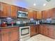 Kitchen with stainless steel appliances, granite counters, dark wood cabinets, and mosaic tile backsplash at 1516 Arrowhead Trl, Enterprise, FL 32725