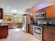 Spacious kitchen features dark wood cabinetry, stainless steel appliances, and lots of natural light at 1516 Arrowhead Trl, Enterprise, FL 32725