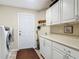The laundry room has white cabinets and modern washer and dryer units for efficient chore completion at 1516 Arrowhead Trl, Enterprise, FL 32725