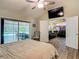 Light-filled main bedroom shows wood-look floors, vaulted ceiling, and lanai access with a view of the private pool at 1516 Arrowhead Trl, Enterprise, FL 32725