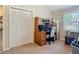 This home office features a wood desk, storage cabinets, and a window to provide ample natural light at 1516 Arrowhead Trl, Enterprise, FL 32725