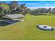An aerial view of a green field features a covered pavilion and a fire pit seating area at 1516 Arrowhead Trl, Enterprise, FL 32725