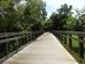 Scenic wooden walkway with green foliage offering an inviting path for community residents and visitors at 1516 Arrowhead Trl, Enterprise, FL 32725