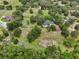 Wide aerial view revealing a home, pool, outbuilding, and extensive acreage enveloped by lush trees at 1555 Mercers Fernery Rd, Deland, FL 32720