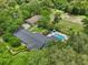 Aerial view of a property boasting a home, separate garage, pool, and mature trees at 1555 Mercers Fernery Rd, Deland, FL 32720