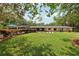 Expansive backyard featuring a lush lawn, privacy landscaping, and charming brick accents at 1555 Mercers Fernery Rd, Deland, FL 32720